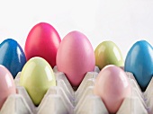 Coloured eggs in an egg box