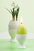 Snow drops in Easter egg and egg-shaped candle