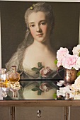 Baroque portrait of a woman behind perfume flagons and cut roses in brass pitcher