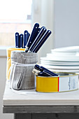 Tin cans wrapped with fabric used as cutlery holders
