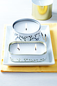 Decorative tin can candles wrapped in decorative white paper