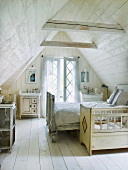 Wood-panelled attic bedroom with cot and double bed