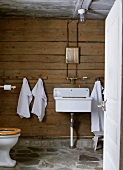 Simple sink on wooden wall in rustic bathroom