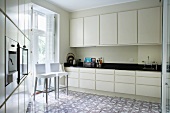Modern kitchen with ornamental, patterned tiled floor