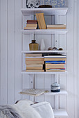 Simple shelves of books on white wooden wall