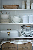 Bread box and wire basket on open-fronted, white shelving