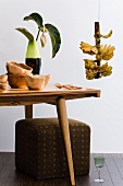 Retro-style living room (wooden table, stool, wooden bowls, banana plant)