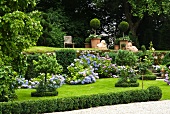 Sommergarten auf zwei Ebenen mit blühenden Hortensien