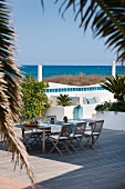 Idyllic terrace complex with set table, comfortable benches and sea view