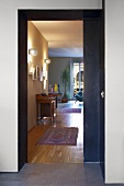 View of modern interior with traditional ambiance through open sliding door - runner on parquet floor and antique bureau