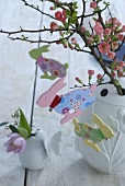 Branch of flowering quince decorated with wooden Easter bunnies