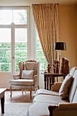 Rococo-style armchair, sofa and side table in corner in front of French doors