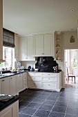 Küche mit weissen Schrankfronten im Landhausstil und moderner Fliesenboden in Grau