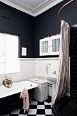 Black and white bathroom with Victorian bathtub and shower area