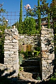 View between two stone posts into Mediterranean garden