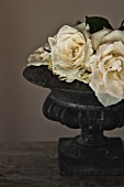 White roses in antique stone planter