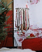 Festive chandelier made from lampshade frame decorated with strings of beads and candles