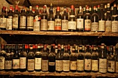 Dusty wine bottles on old shelving