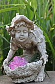 Stone figurine of child decorated with flowers