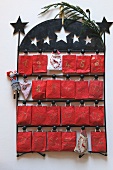Advent calendar - little red sacks hanging on black metal frame