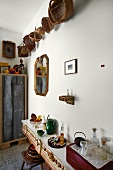 Collection of baskets on wall above hodgepodge of flea-market finds on sideboard