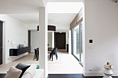Blick in offenen Designer Wohnraum mit Essplatz in Schwarz und gehängtem Sideboard an Wand
