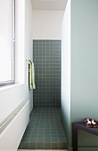 Grau gefliester Duschbereich in minimalistischem Bad