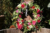 Summer wreath of hydrangeas, asters, sage and grasses hanging on well