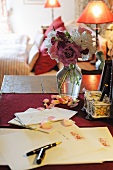 Letter and stylus next to bunch of roses