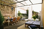 Mediterranean patio area with bed, table, chairs and an elegant mosquito net