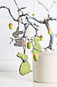 Easter arrangement with rabbits and eggs hanging from branch