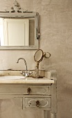Original vintage bathroom with ornate mirror frame and old dressing table as base cabinet for sink