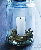 Candle and pieces of spruce twig in preserving jar