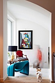 Ausgefallener, blauer Designersessel und antiker Polsterstuhl kombiniert mit kubistischer Malerei als kleiner Sitzplatz in Treppenvorraum
