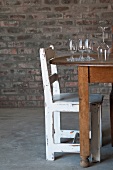 Wine glasses on wooden table and rustic chair