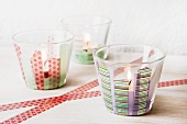 Three tealights in small glasses decorated with masking tape