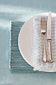 A place setting with silver cutlery on a place mat