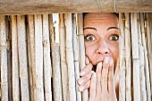 Close up of woman gasping behind fence