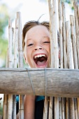 Close up of boy smiling behind fence