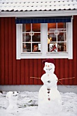 Snowmen standing outside house
