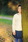 Girl leaning on tree in park