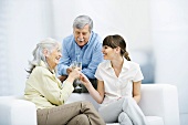 Senior parents and adult daughter clinking champagne glasses, smiling