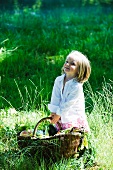 Kleines Mädchen mit Picknickkorb auf der Wiese