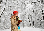 A woman drinking coffee in a winter landscape