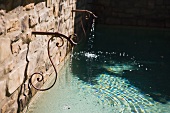 Cast iron fountain trickling into pool
