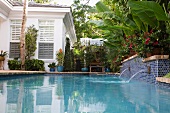 Tropischer Garten einer eleganten Villa mit Wasserspeiern im mediterranen Pool