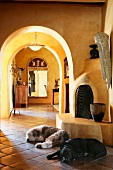 Pet dogs laying on tile floor in front of kiva fireplace