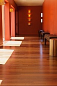 Hardwood floor in hallway with doorways and benches