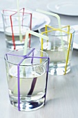 Glasses of water decorated with colourful rubber bands