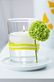 Floating candle in glass with flower held on by rubber band
